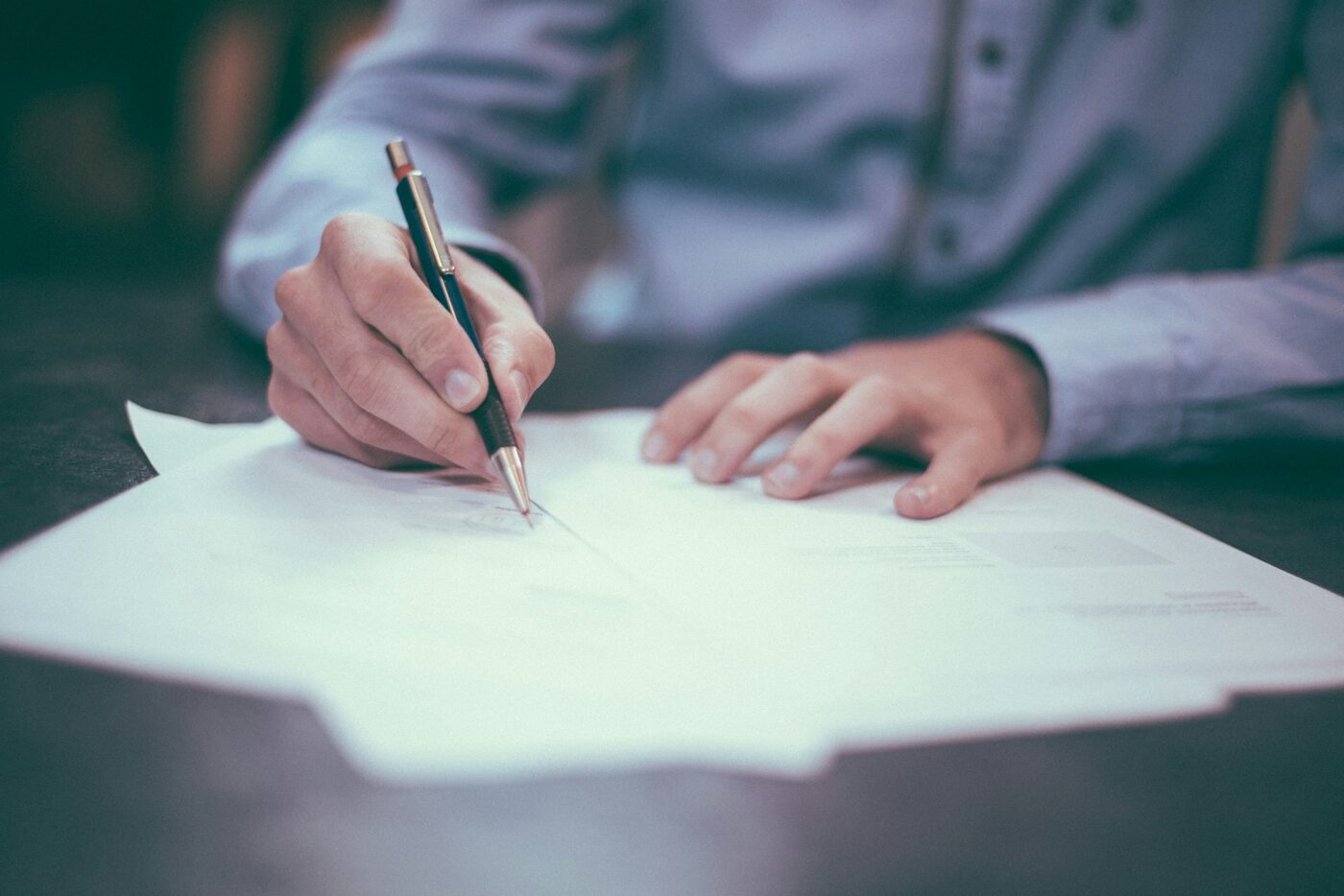 A North Vancouver accountant reviewing and signing tax paperwork at a desk